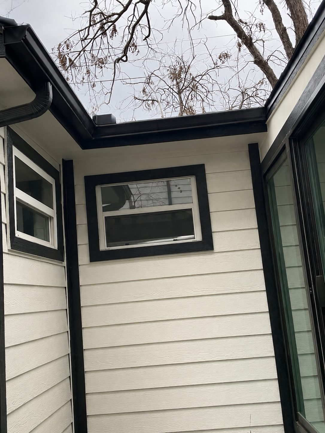 Black gutter wrapping a courtyard corner on a modern white home.