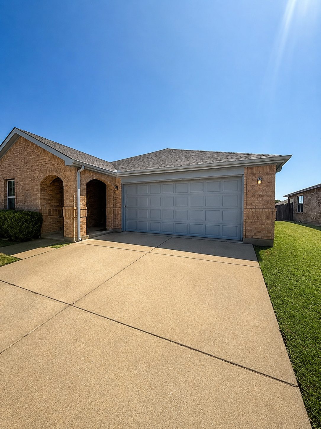Classic white gutters on a red brick home — matched to the garage trim.