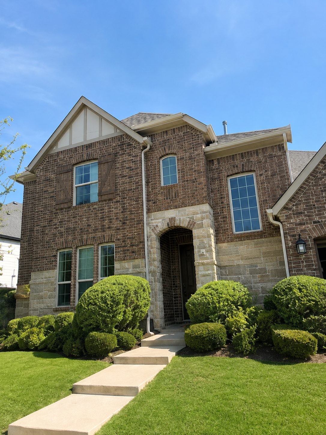 Dark bronze gutters blended into a two-story brick home's trim.