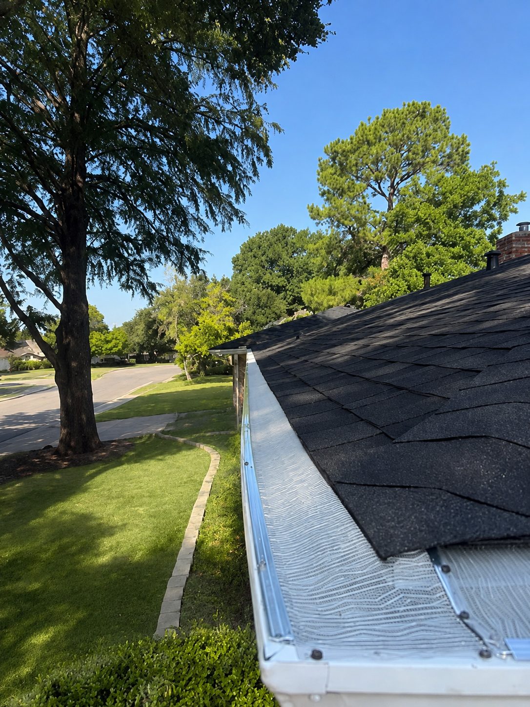 Micro-mesh gutter guard along a roofline — no roof penetrations.